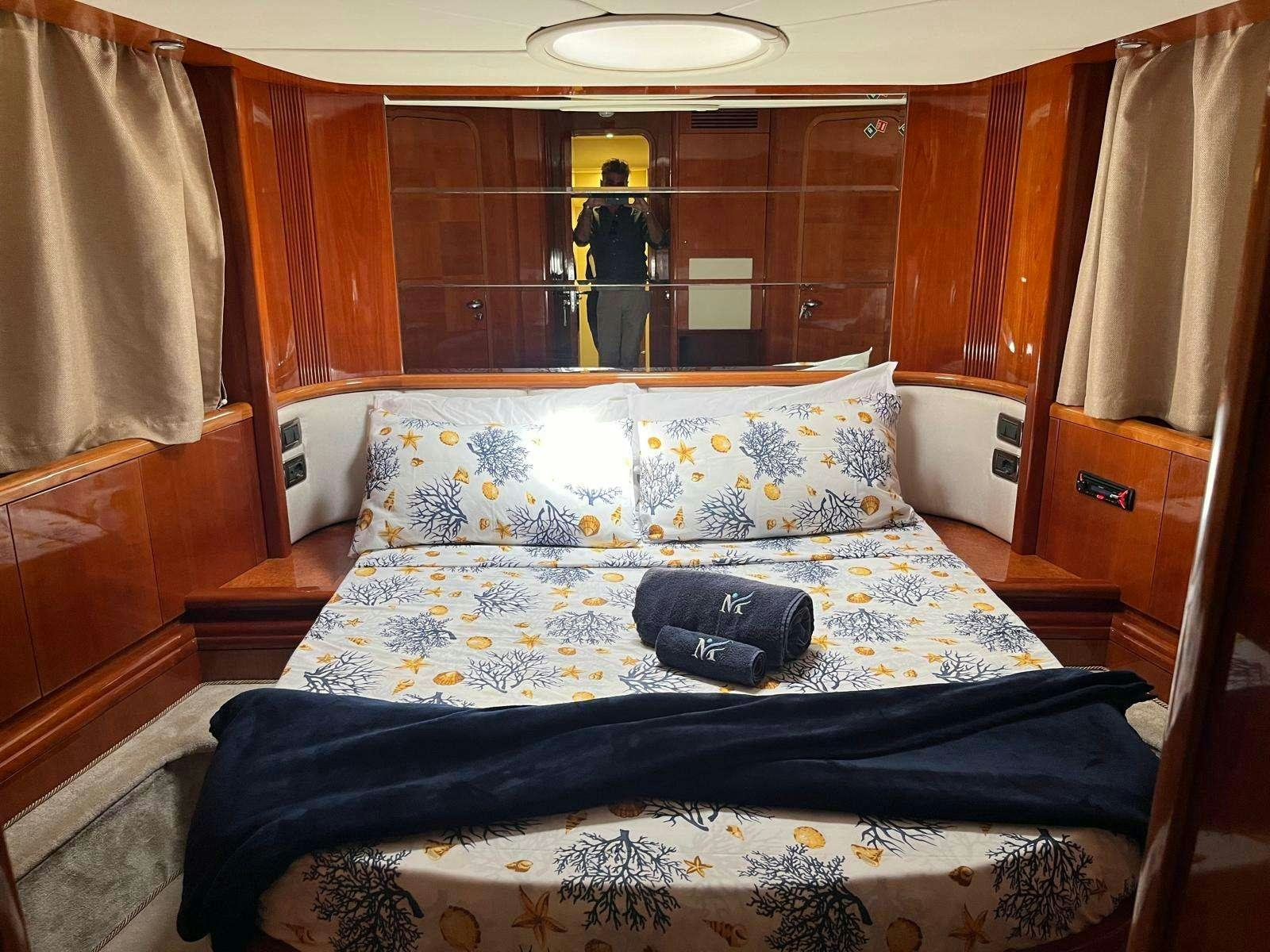 a bed with a blue blanket aboard MINERVA Yacht for Charter
