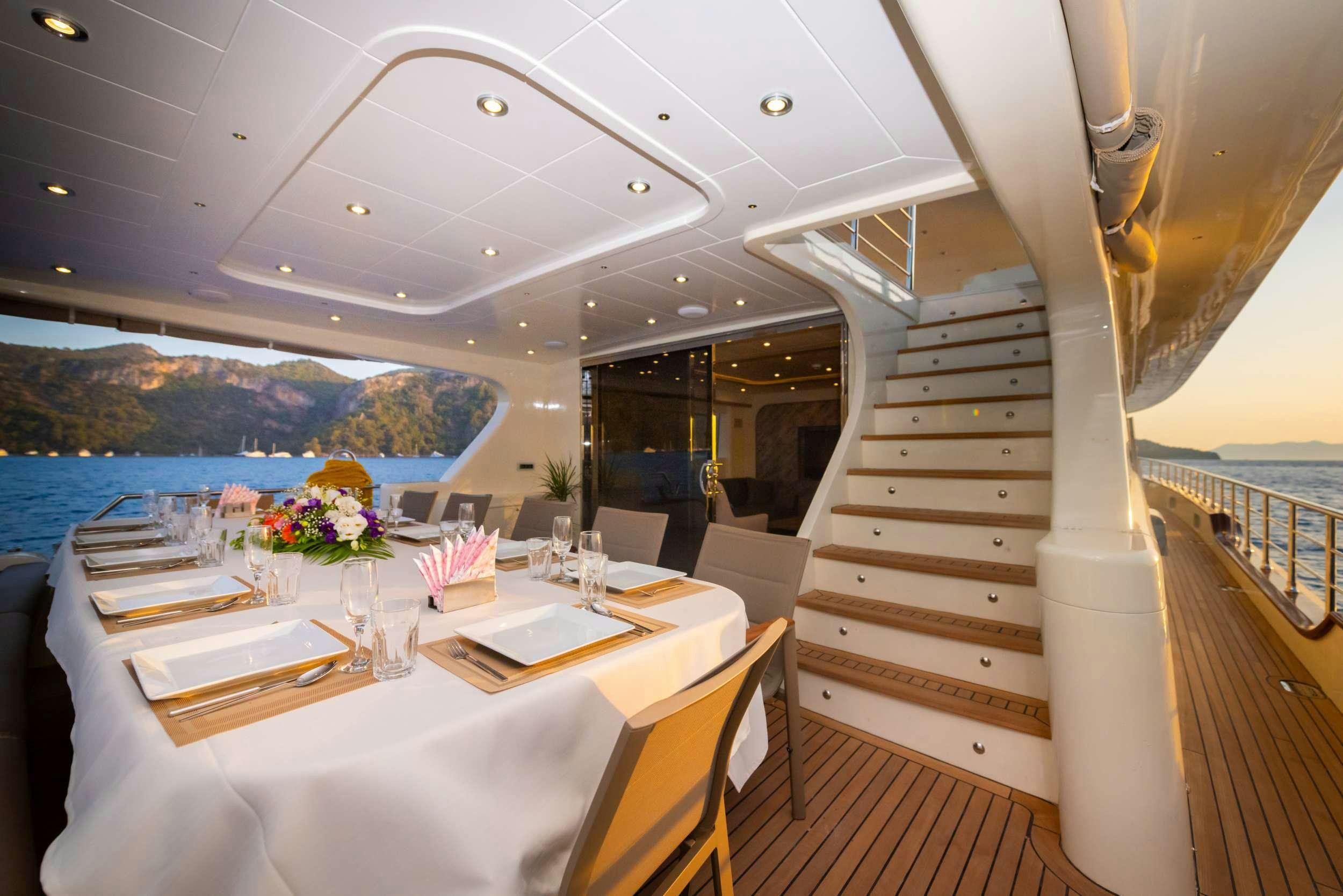 a table with chairs and a view of the ocean aboard 88 YACHT Yacht for Charter