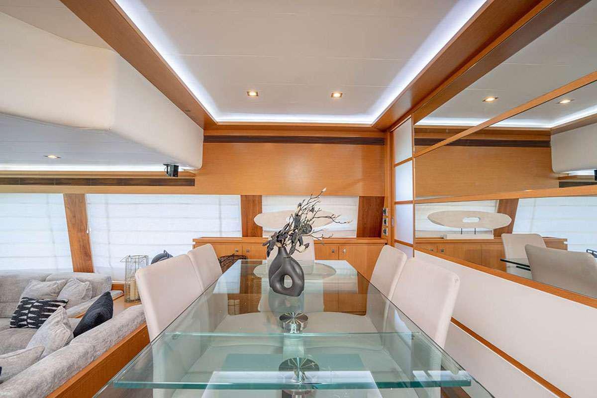 a room with a glass table and couches aboard TWE11VE Yacht for Charter