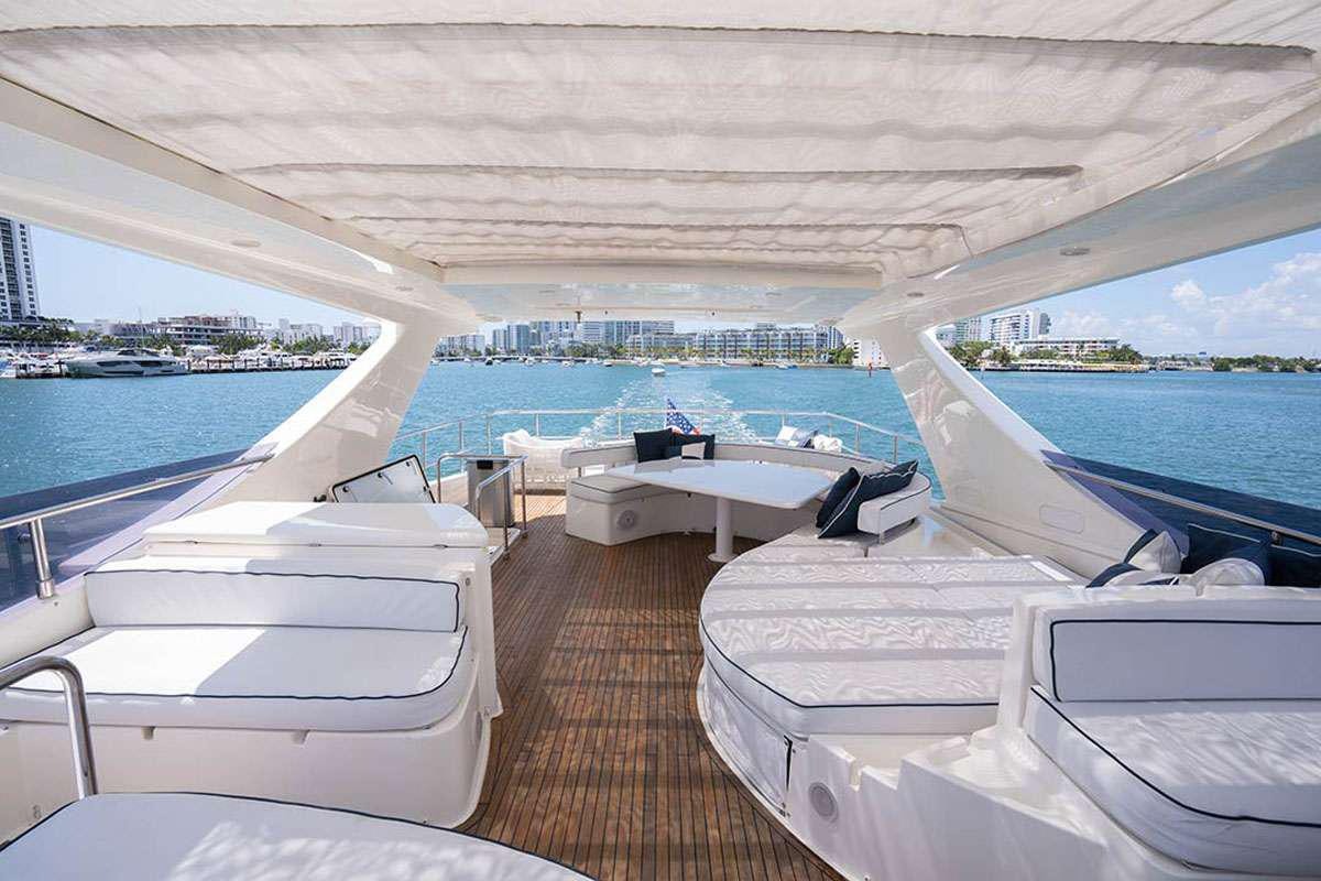 a boat dock with lounge chairs aboard TWE11VE Yacht for Charter