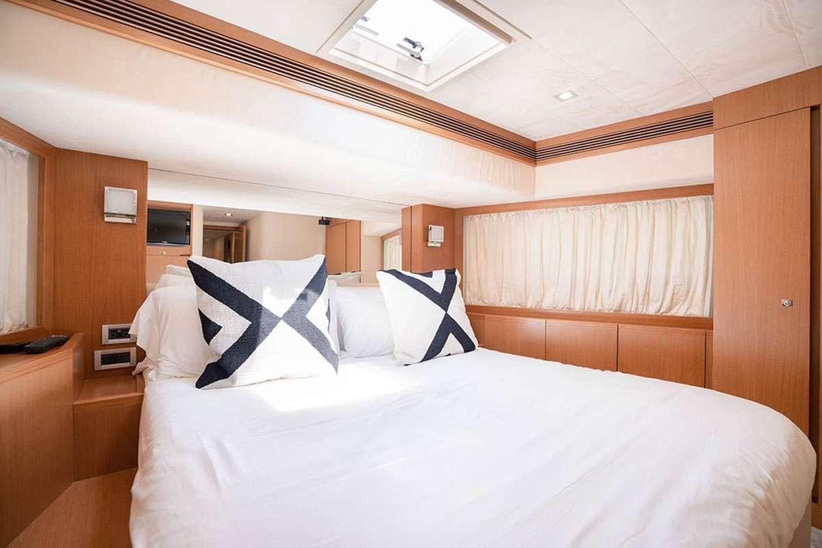 a bed with white sheets aboard TWE11VE Yacht for Charter
