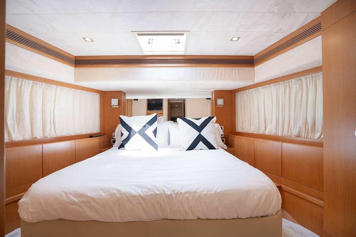a bed with white sheets aboard TWE11VE Yacht for Charter