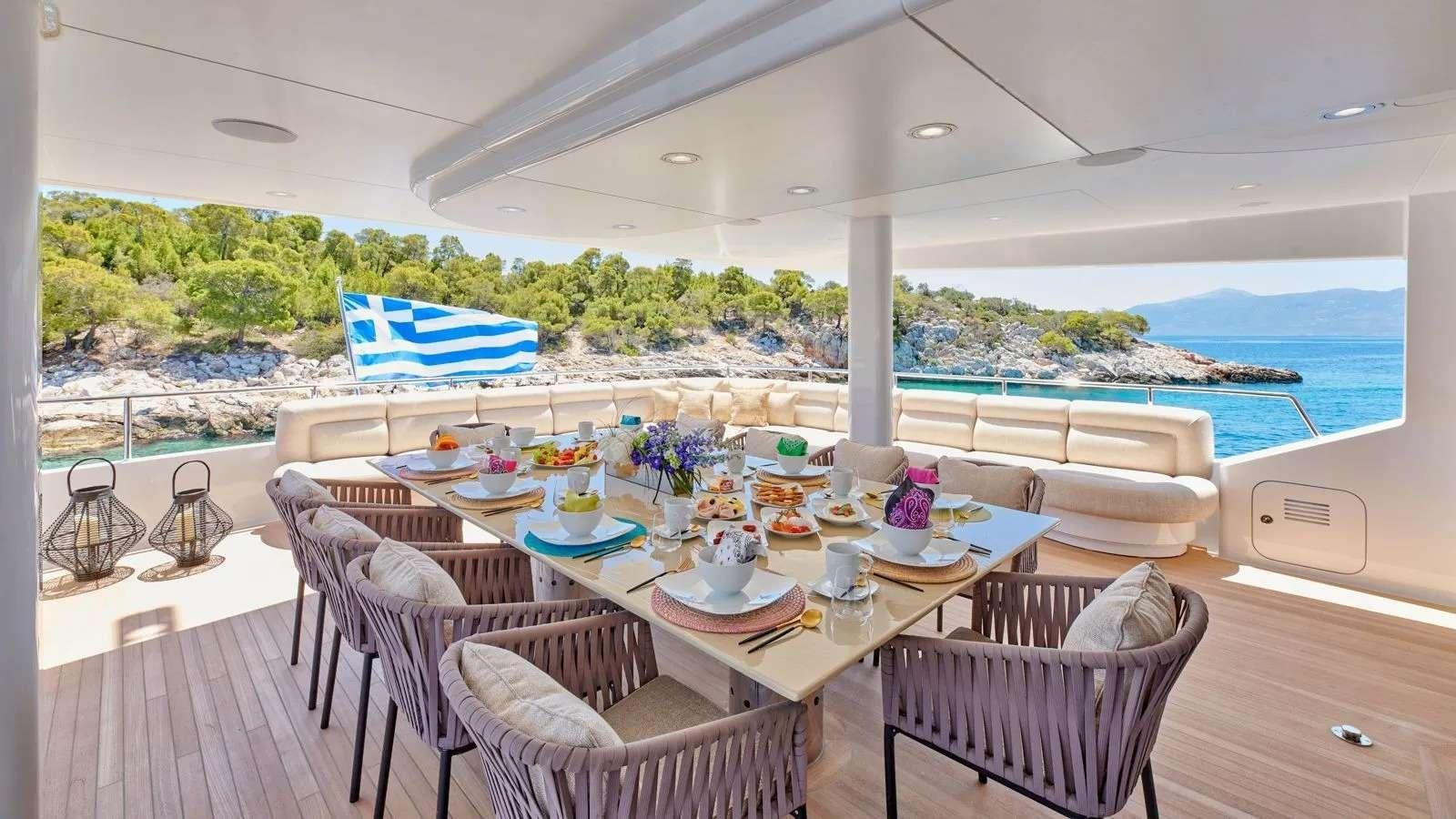 a table set for a meal on a deck overlooking the ocean aboard PROMETHEUS I Yacht for Charter