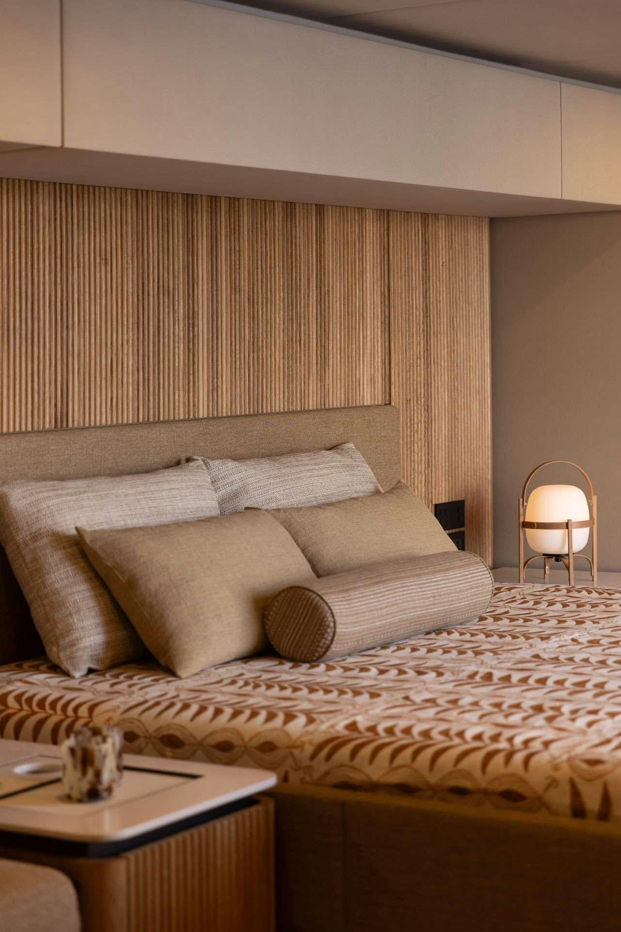 a bed with a pillow and a lamp on it aboard SUNREEF ECO 80 2024 Yacht for Charter