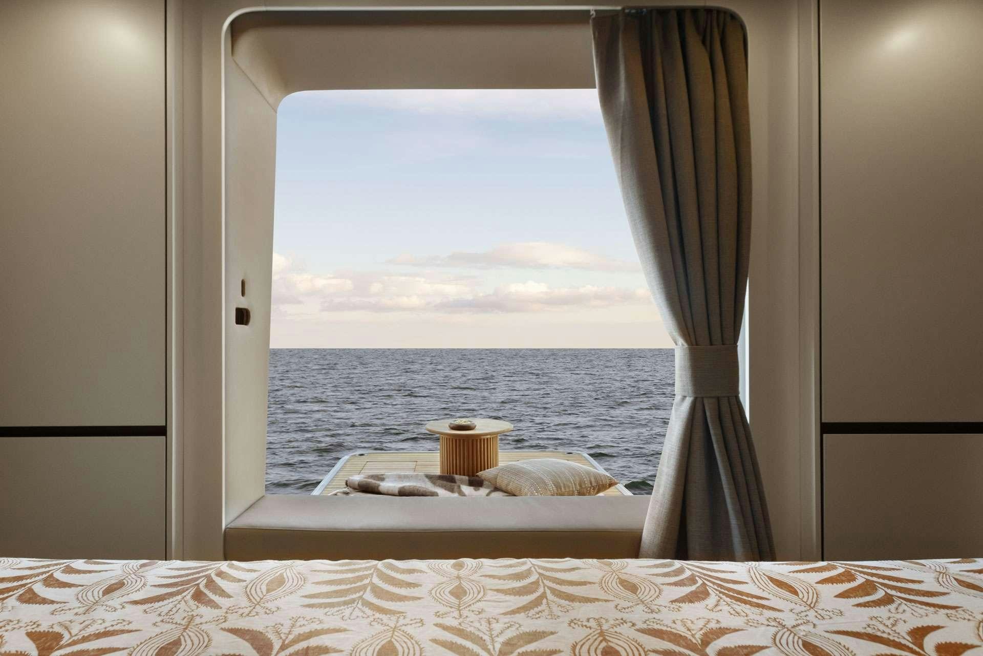 a bed with a window overlooking a body of water aboard SUNREEF ECO 80 2024 Yacht for Charter