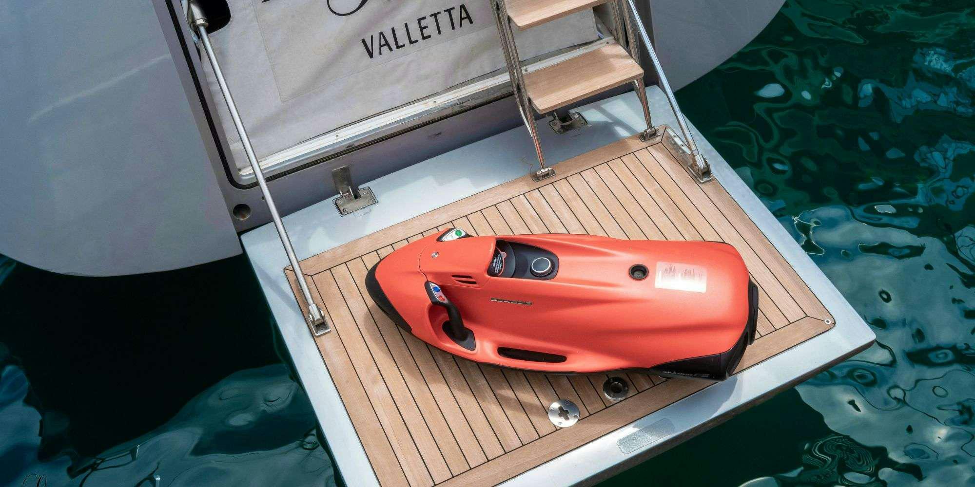 a red and black car on a wooden table aboard LA LOEVIE Yacht for Charter