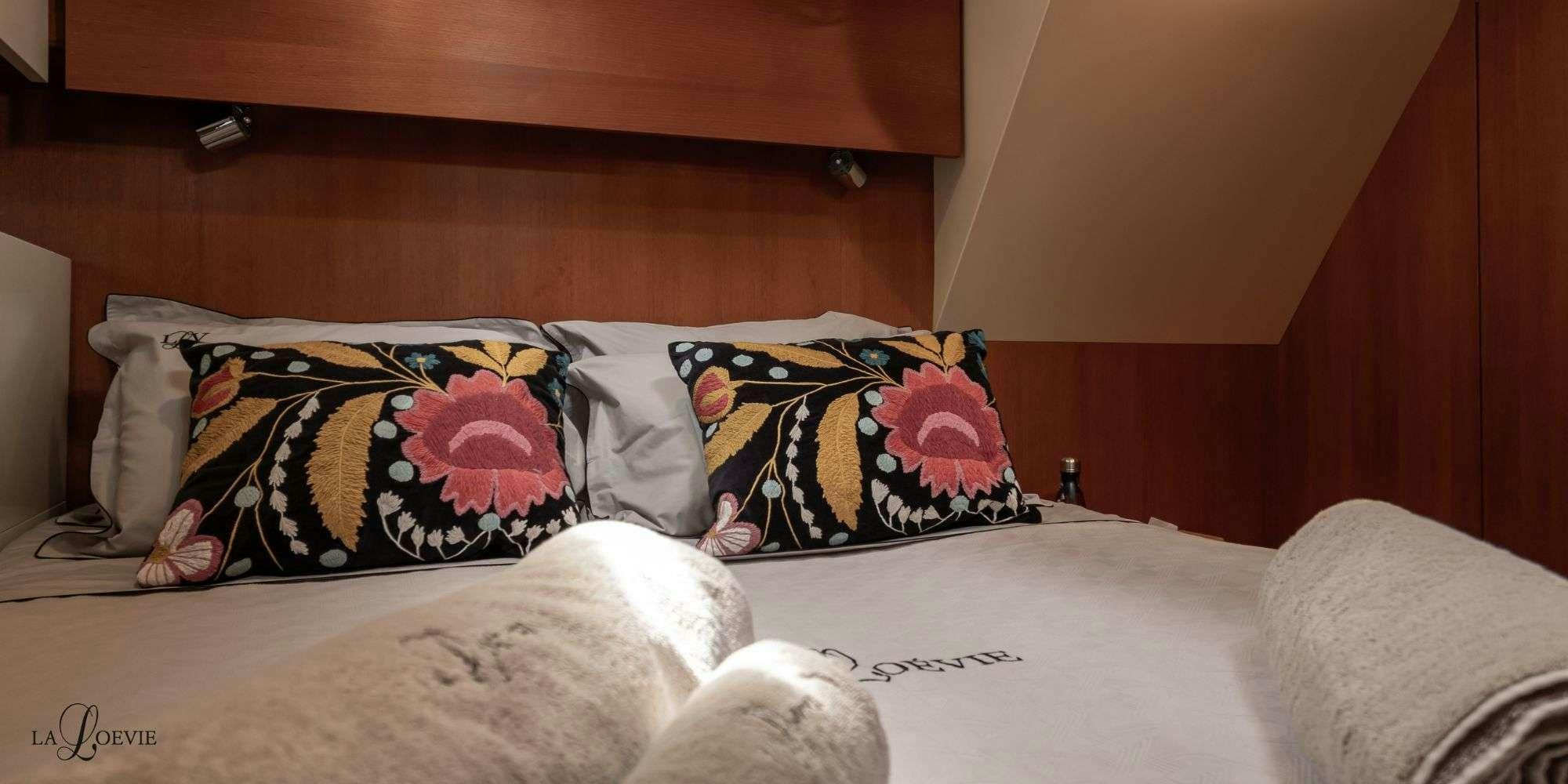 a bed with pillows aboard LA LOEVIE Yacht for Charter