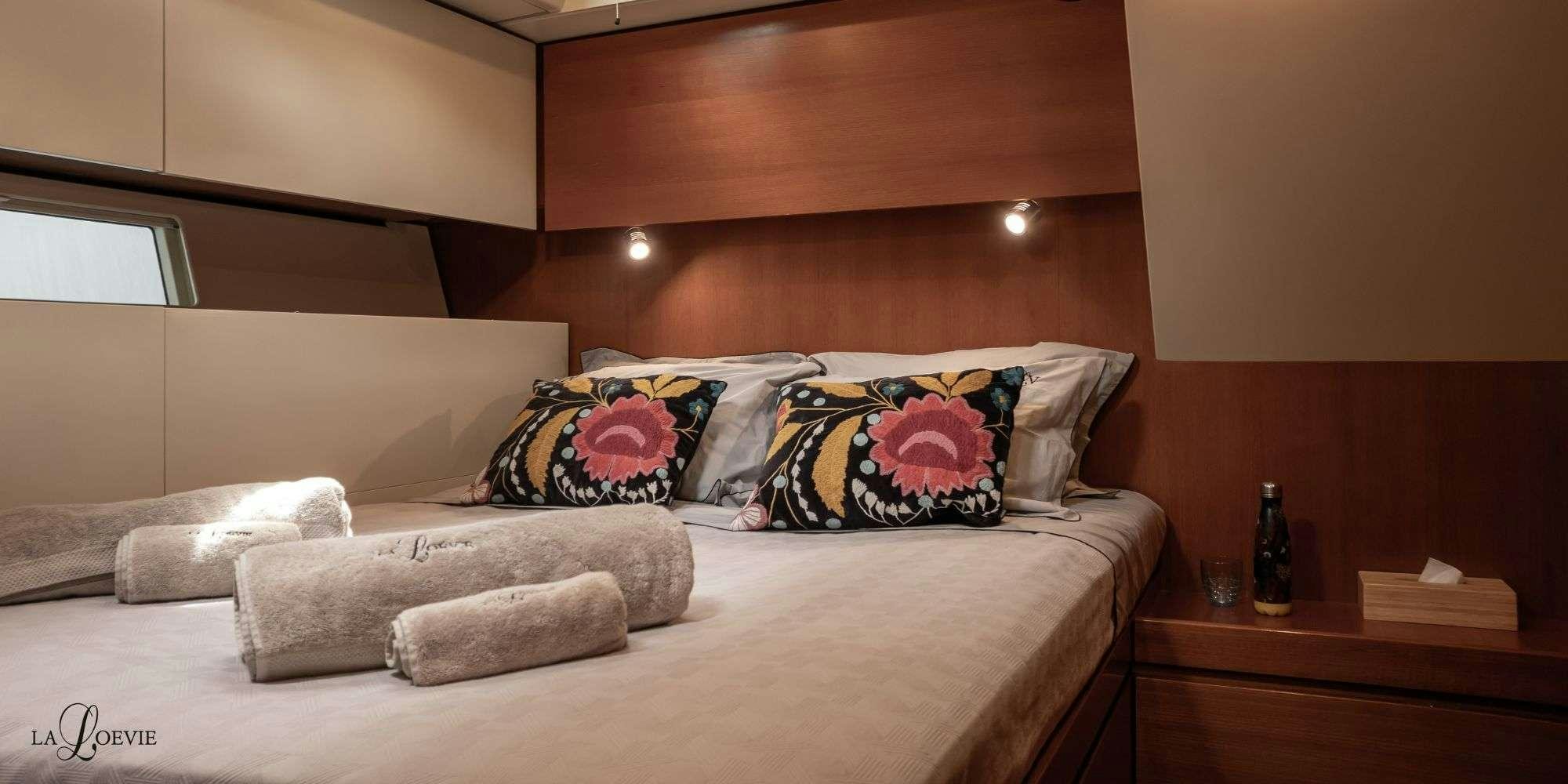 a bed with pillows aboard LA LOEVIE Yacht for Charter