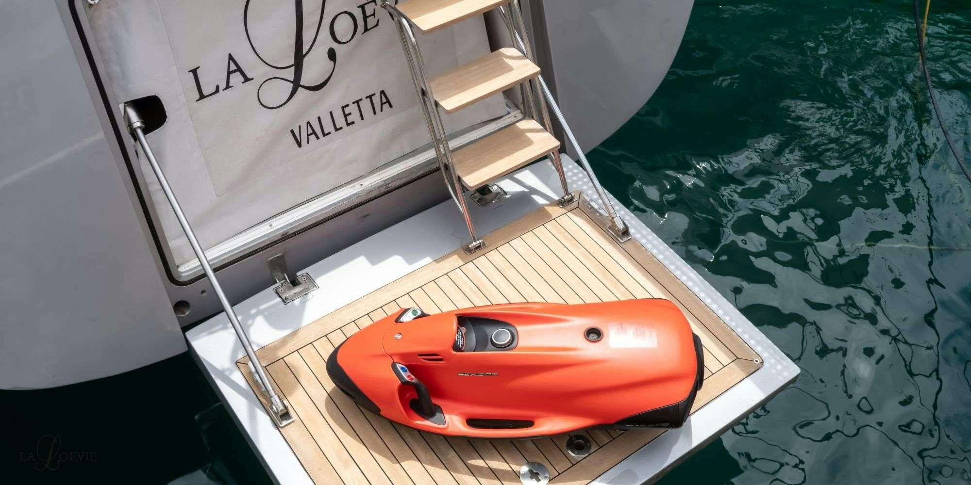 a red and black kayak on a table aboard LA LOEVIE Yacht for Charter