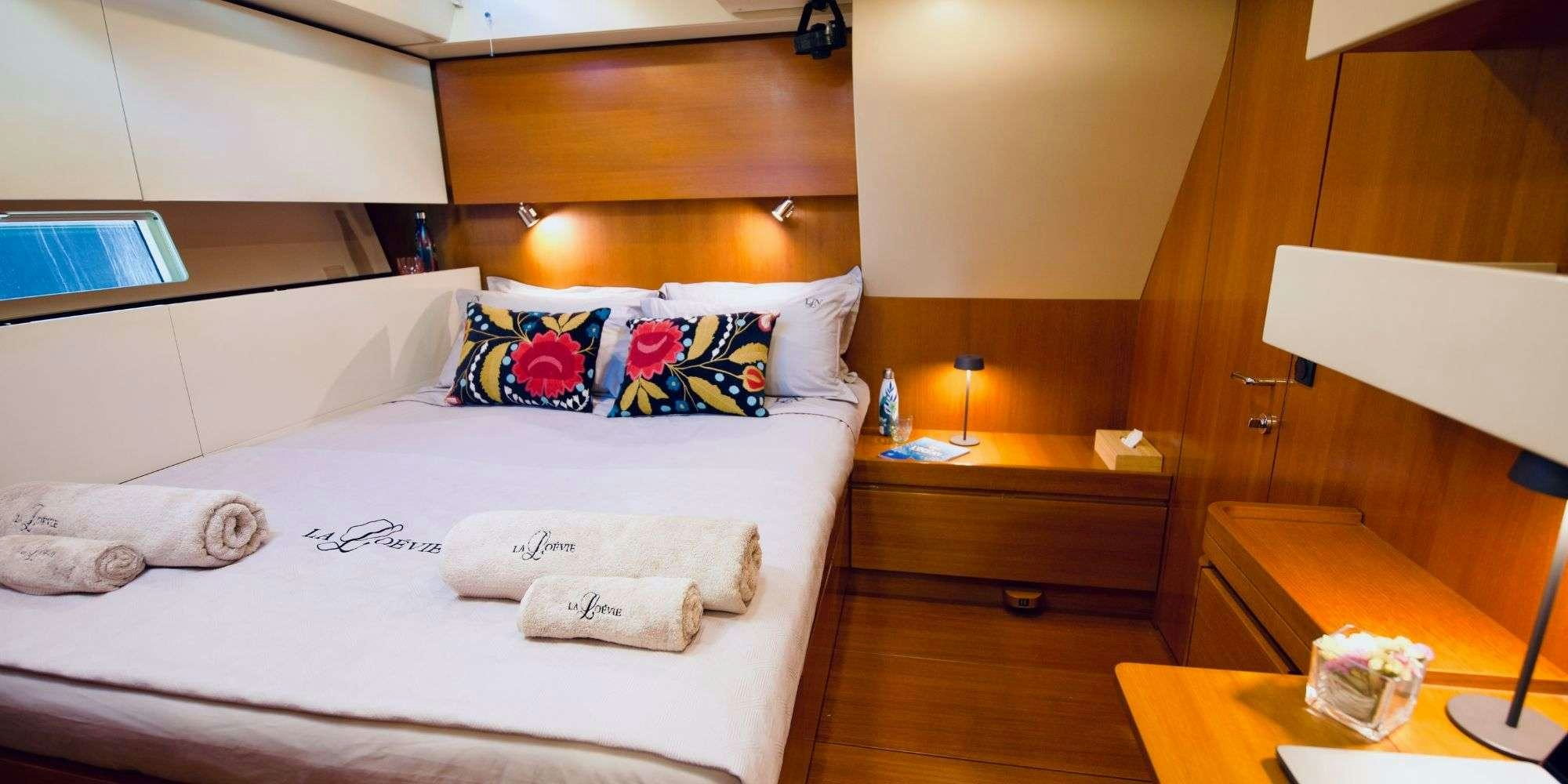 a room with a bed and a desk aboard LA LOEVIE Yacht for Charter
