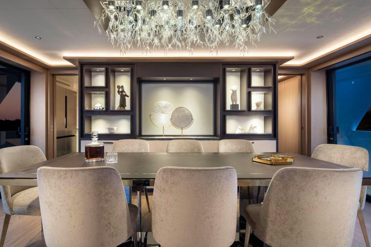 a room with a large chandelier above a bar aboard MAJERA Yacht for Charter