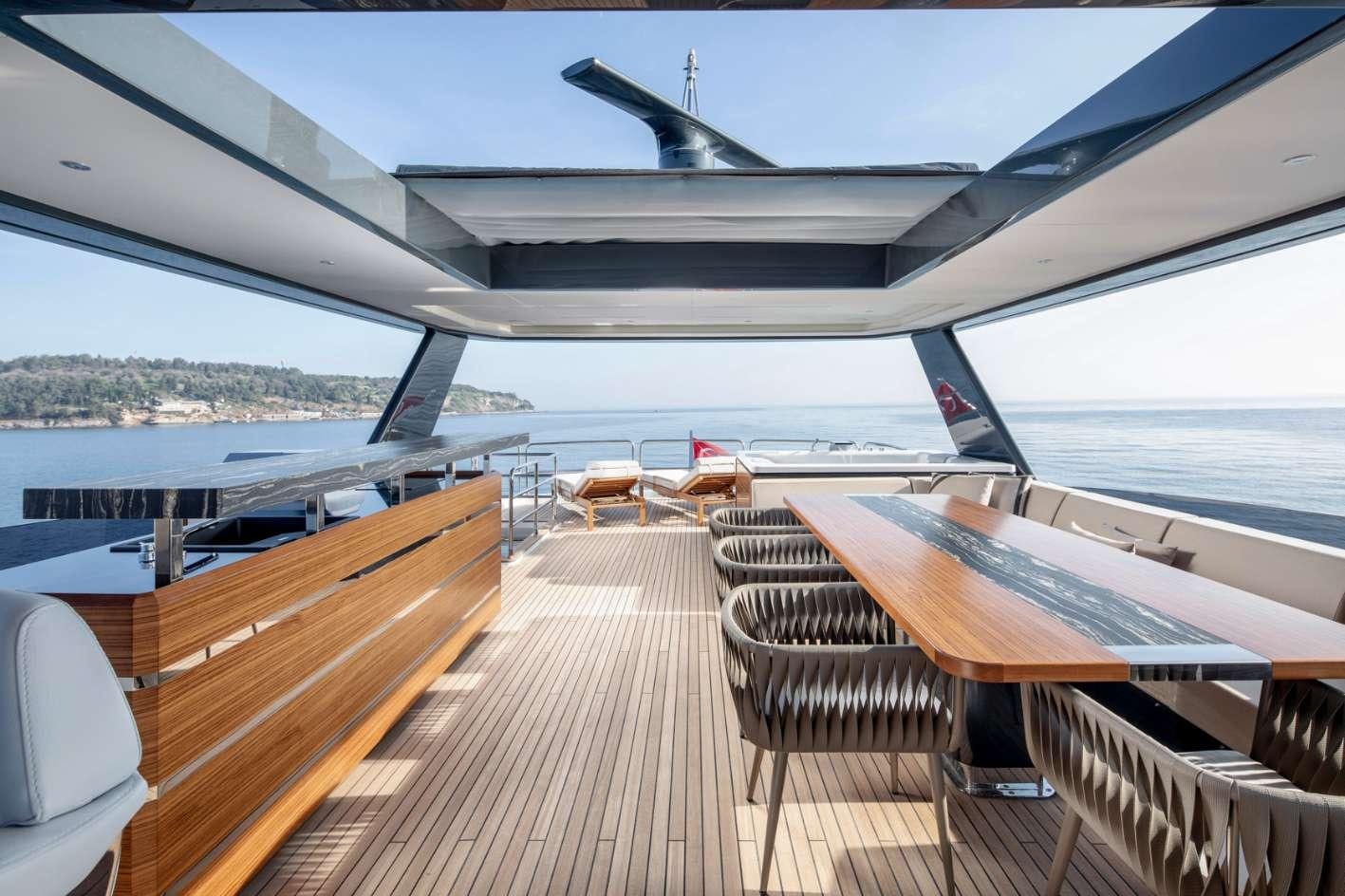a deck with chairs and a plane in the background aboard MAJERA Yacht for Charter