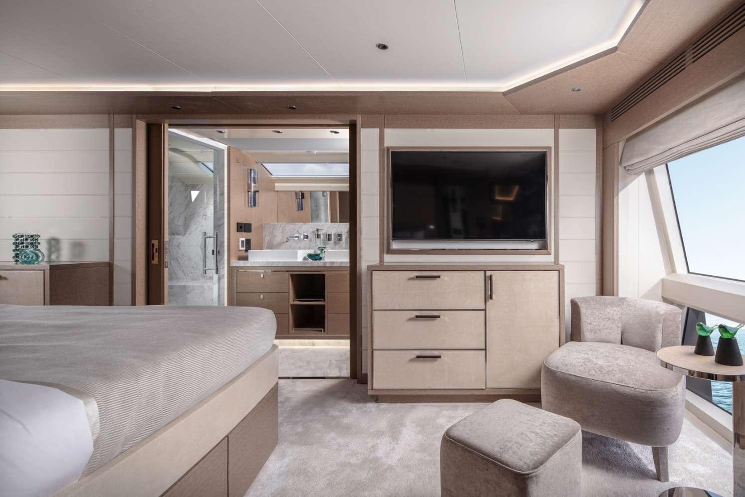 a bedroom with a bed and a television aboard MAJERA Yacht for Charter