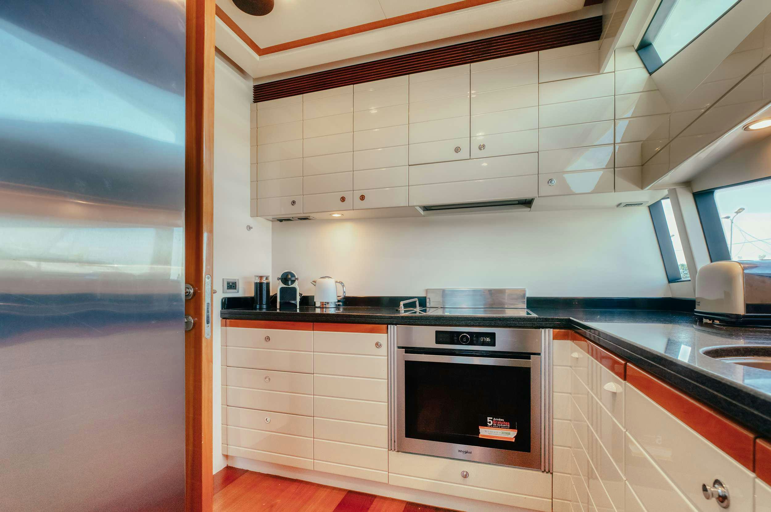 a kitchen with white cabinets aboard LIDIA Yacht for Charter