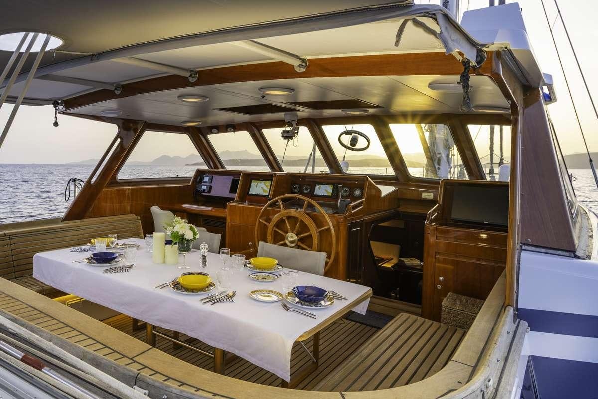 a boat with a table and chairs aboard COLOMBAIO Yacht for Charter