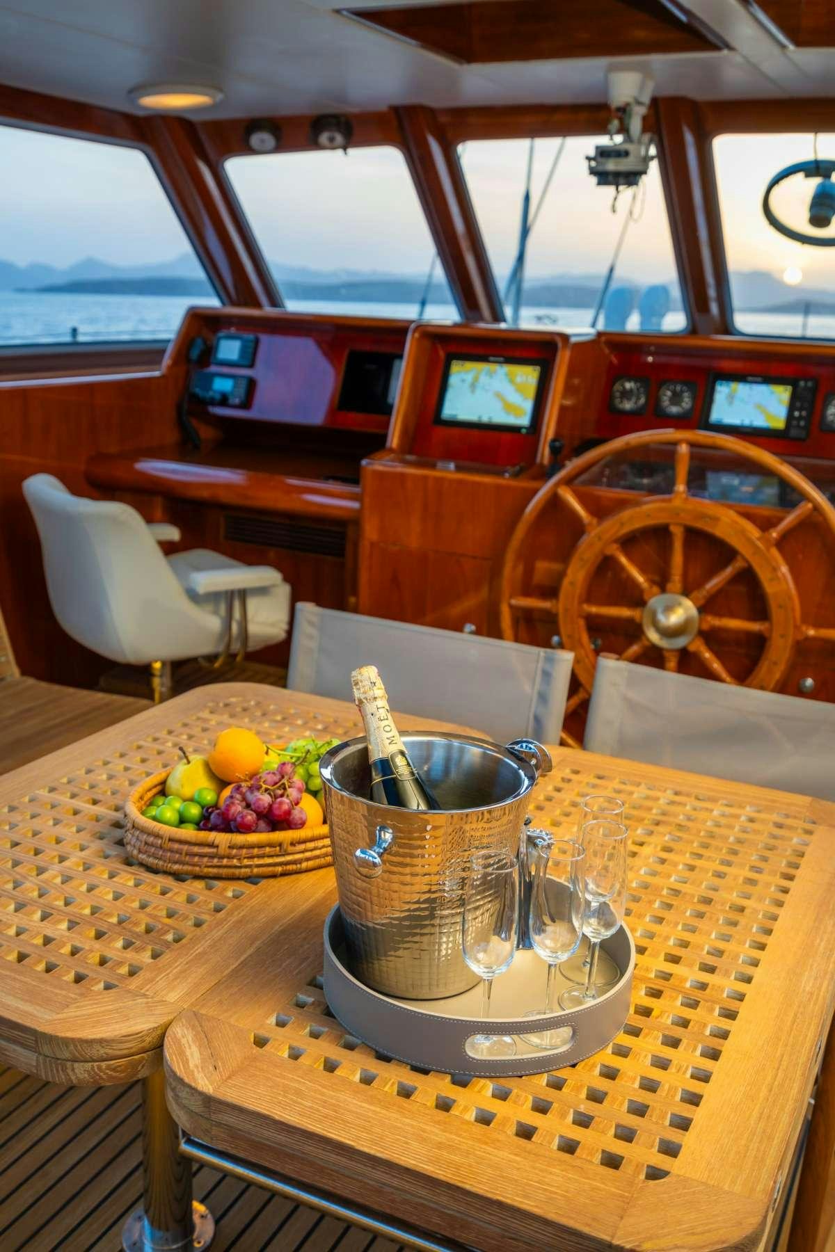 a table with a basket of fruit on it aboard COLOMBAIO Yacht for Charter
