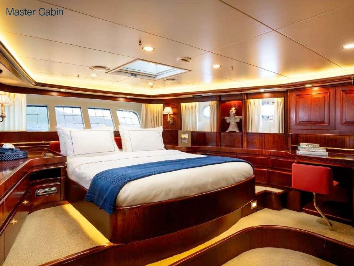 a room with a bed and desk aboard COLOMBAIO Yacht for Charter