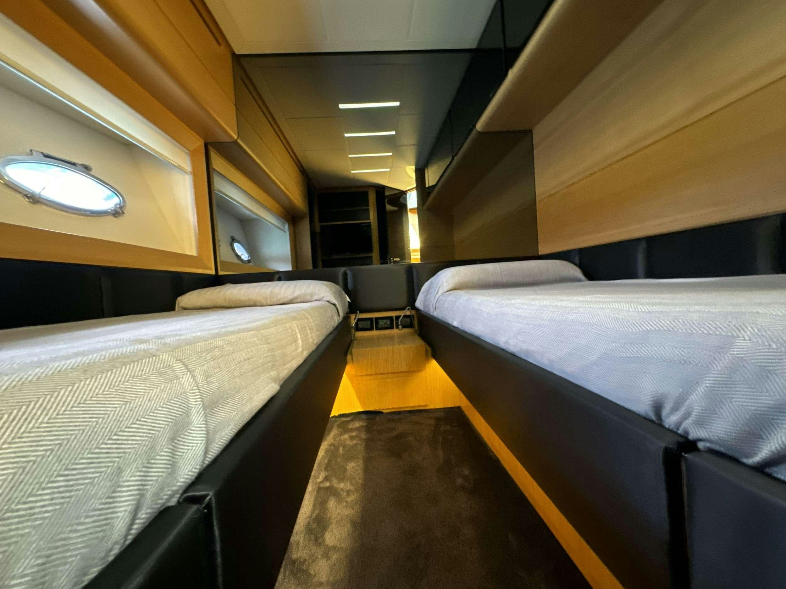 a room with beds and a table aboard SUE&NTILDE;O Yacht for Charter