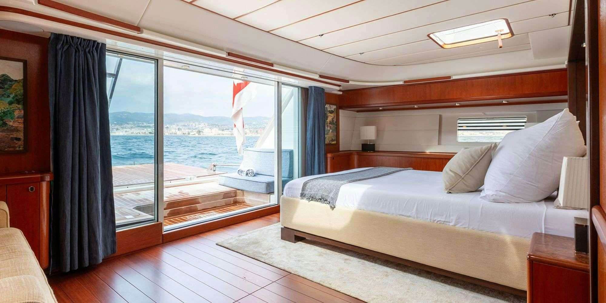 a room with a bed and a large window aboard SELENA Yacht for Charter