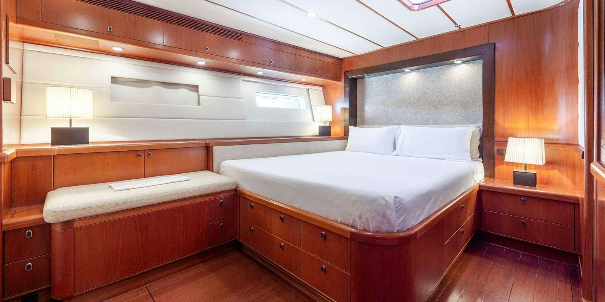 a room with a bed and a desk aboard SELENA Yacht for Charter