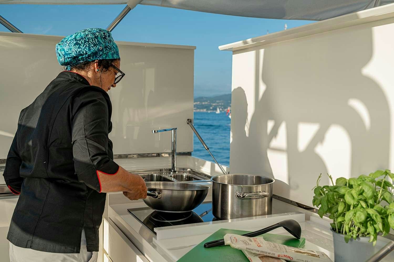 a person cooking in a kitchen aboard ROCK MOON Yacht for Charter