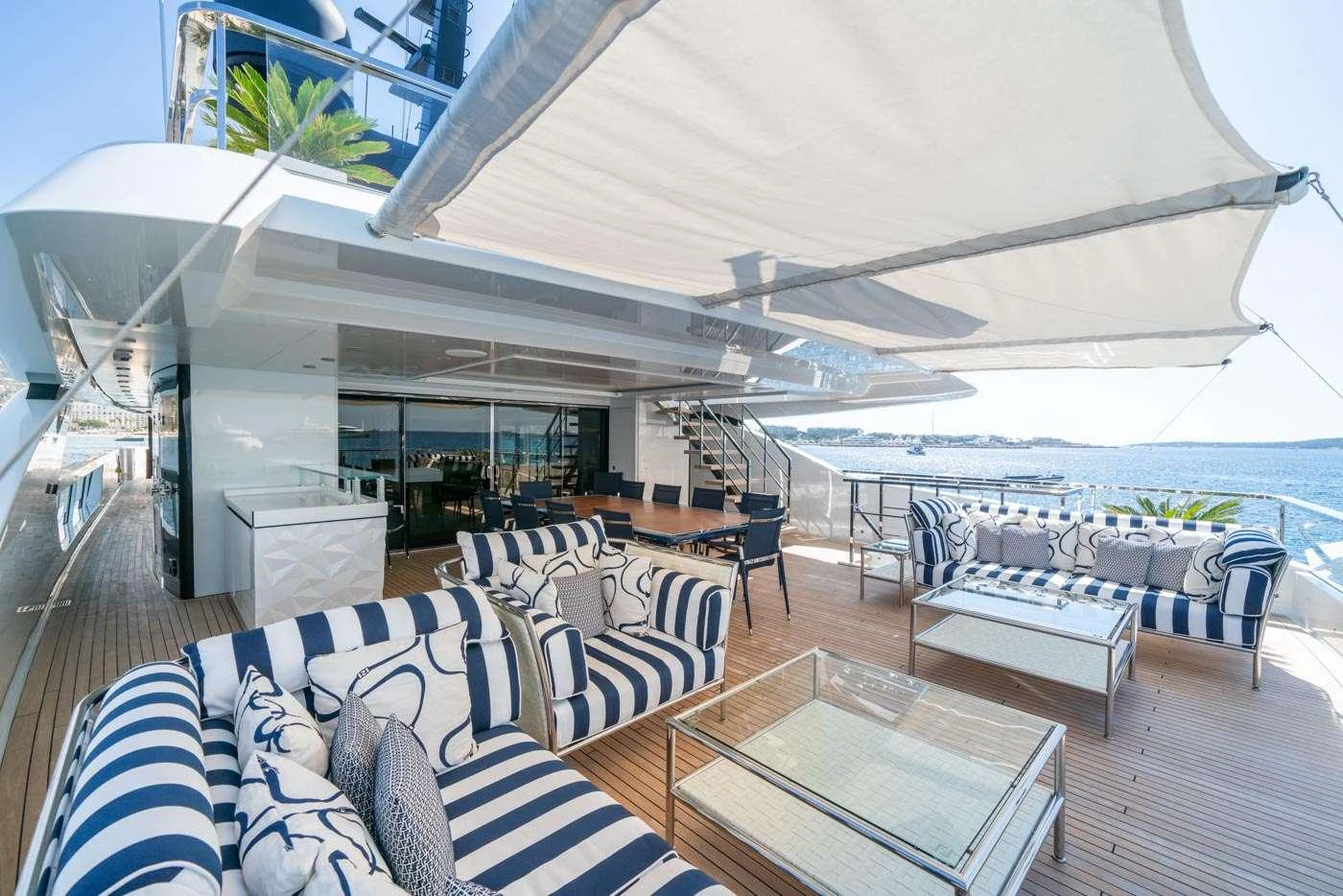 a large living room with a large white lounge chair and a large white umbrella aboard ALULIM Yacht for Charter