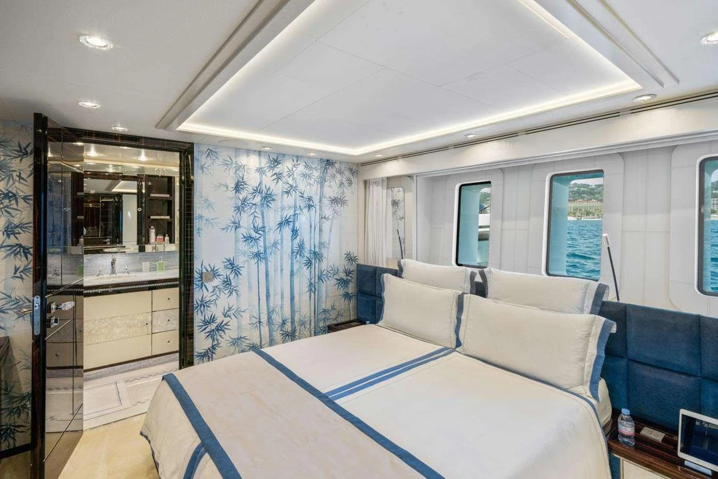 a bedroom with a bed and a mirror aboard ALULIM Yacht for Charter