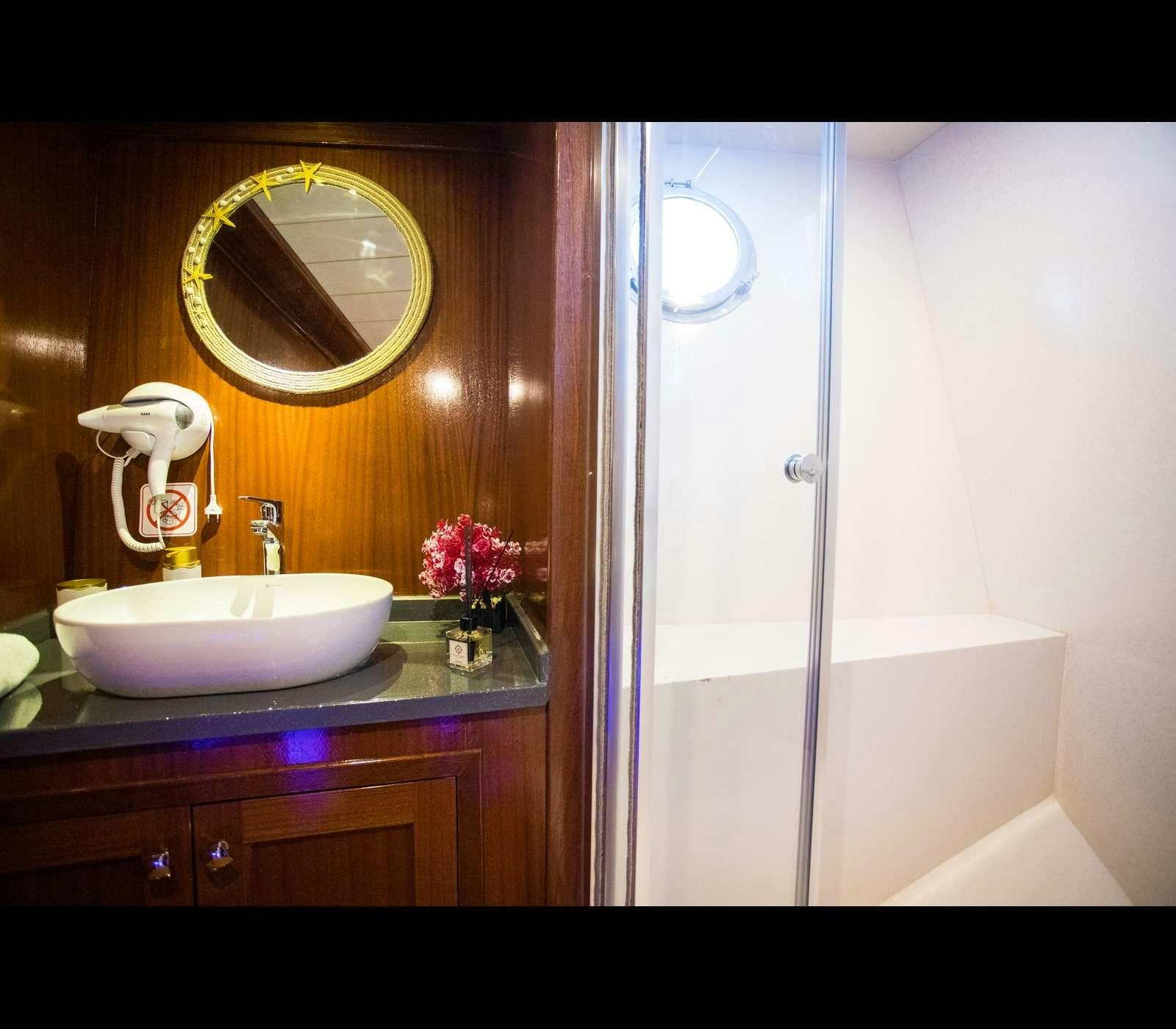 a bathroom with a sink and a mirror aboard QUEEN OF RTT GULET Yacht for Charter