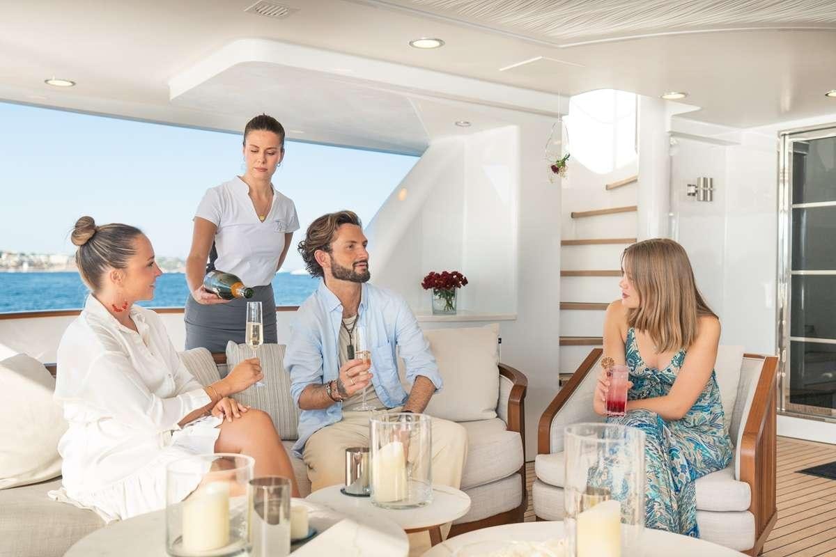 a group of people sitting around a table aboard TITIAN PEARL Yacht for Charter