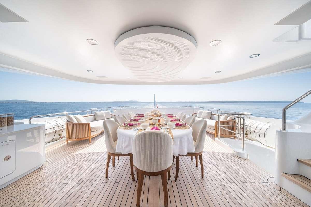 a table and chairs on a deck aboard TITIAN PEARL Yacht for Charter