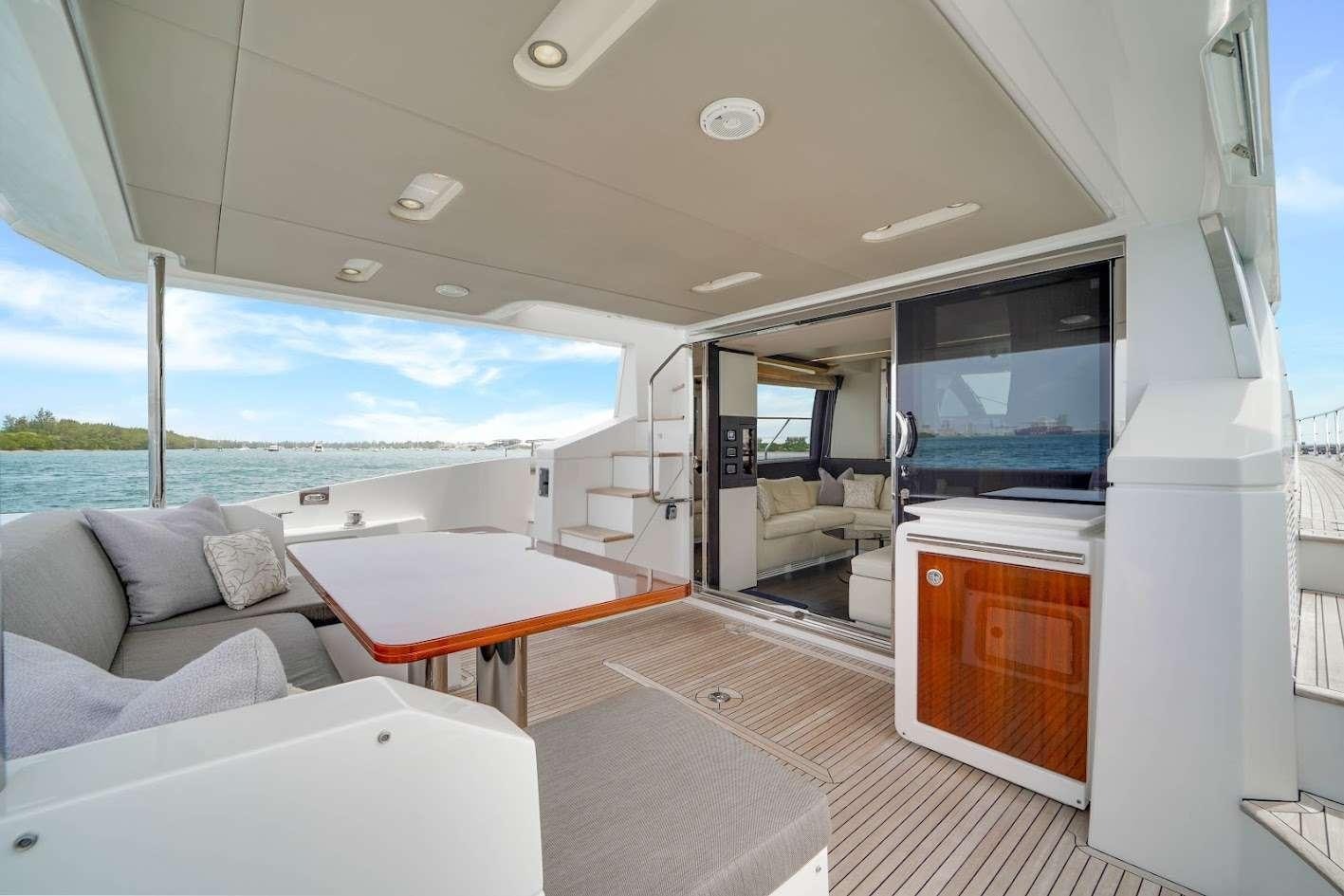 a room with a table and couches aboard THE ONE Yacht for Charter