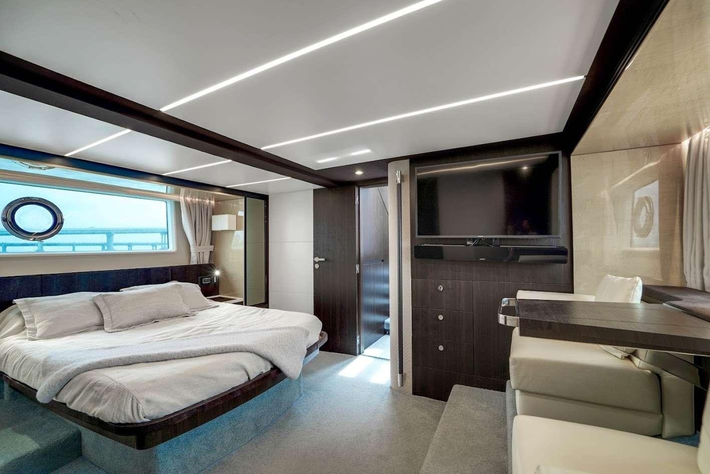 a room with a bed and a desk aboard THE ONE Yacht for Charter