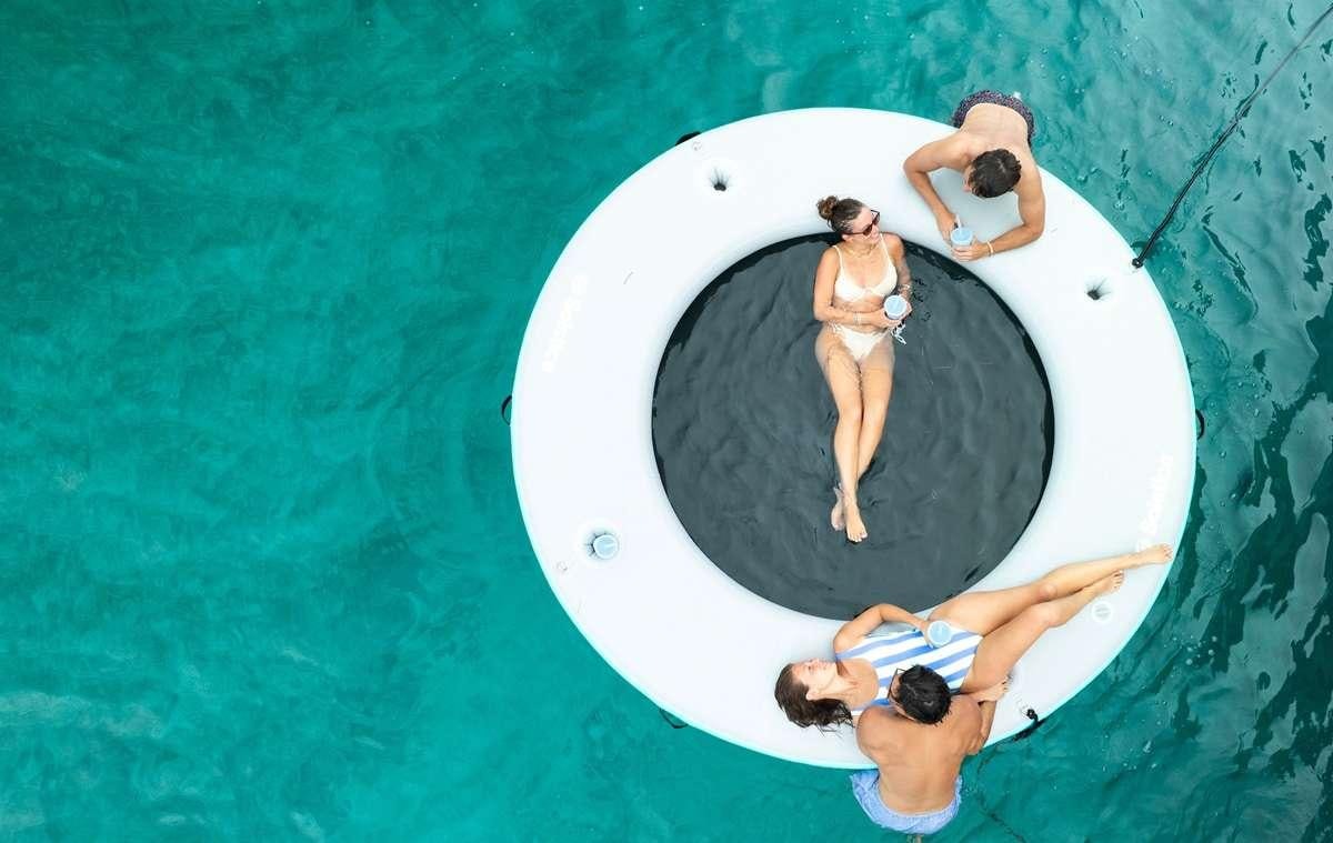a man and woman on a trampoline aboard BLESSED Yacht for Charter