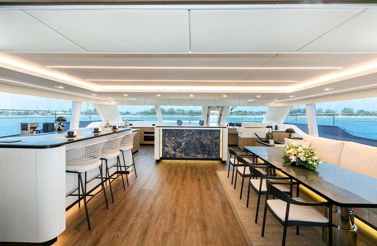 a room with tables and chairs aboard BLESSED Yacht for Charter