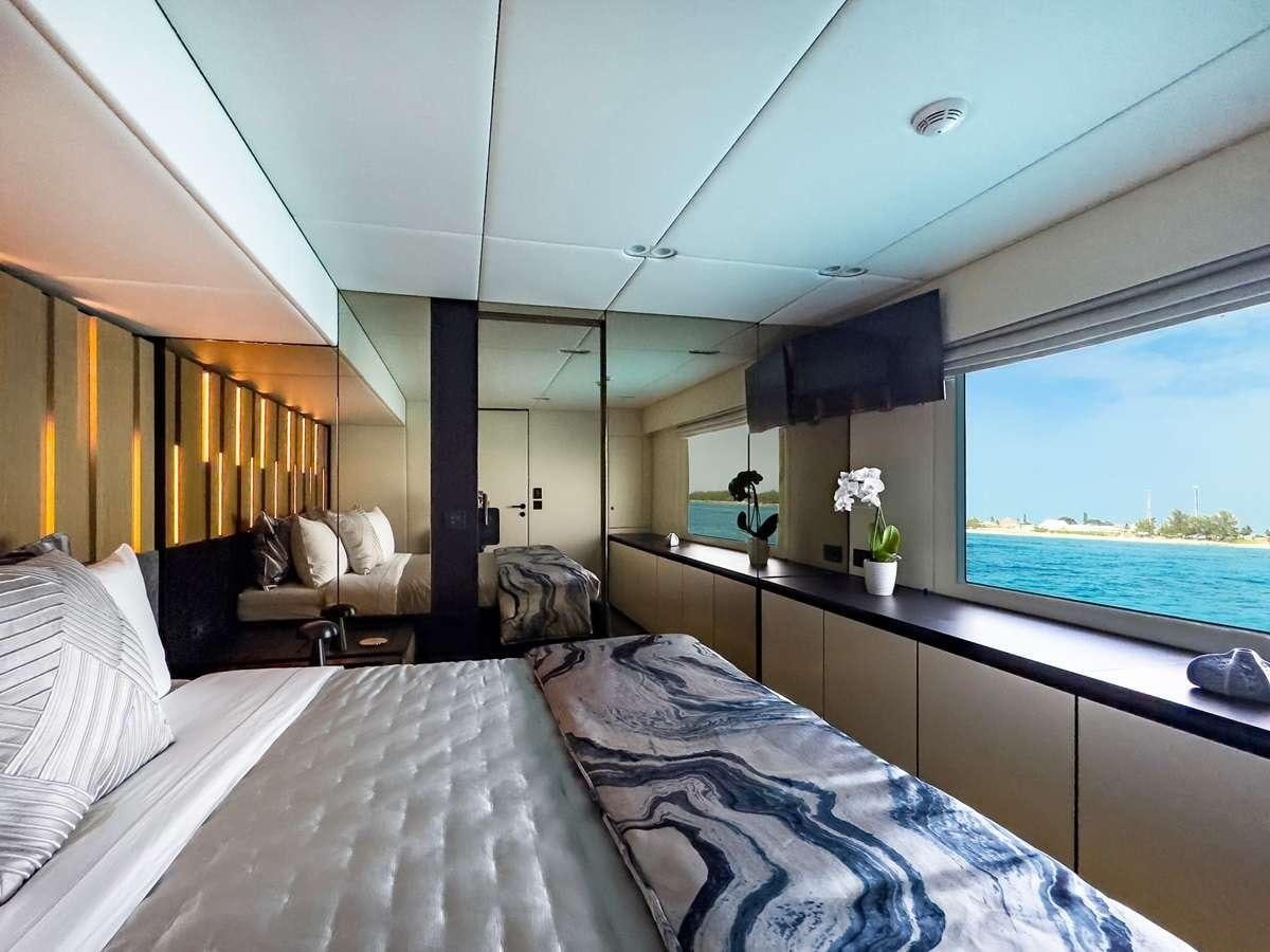 a room with a bed and a large window aboard BLESSED Yacht for Charter