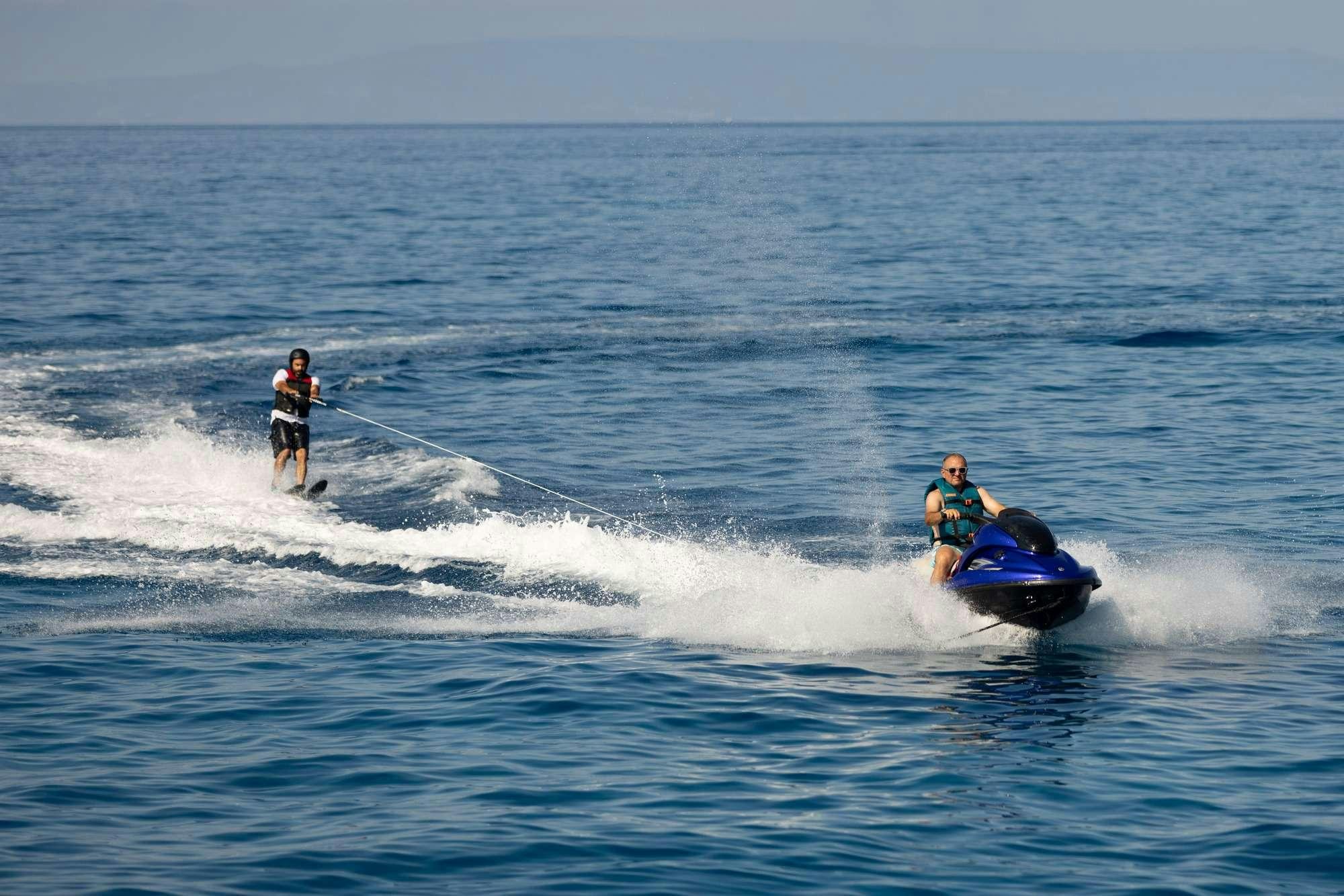 a man and a woman on a jet ski in the ocean aboard OLGA Yacht for Charter