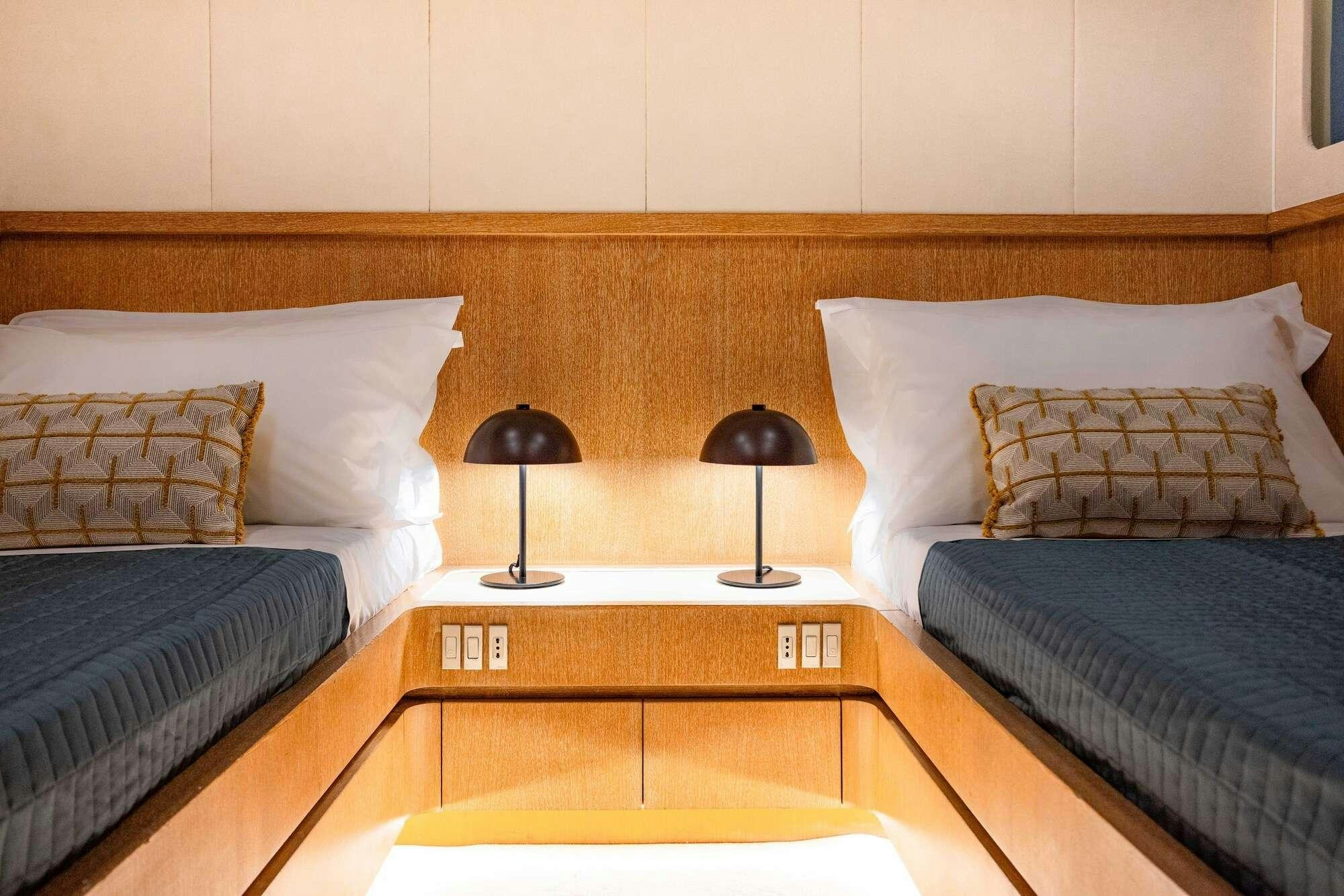 a bed with a table and lamps aboard OLGA Yacht for Charter