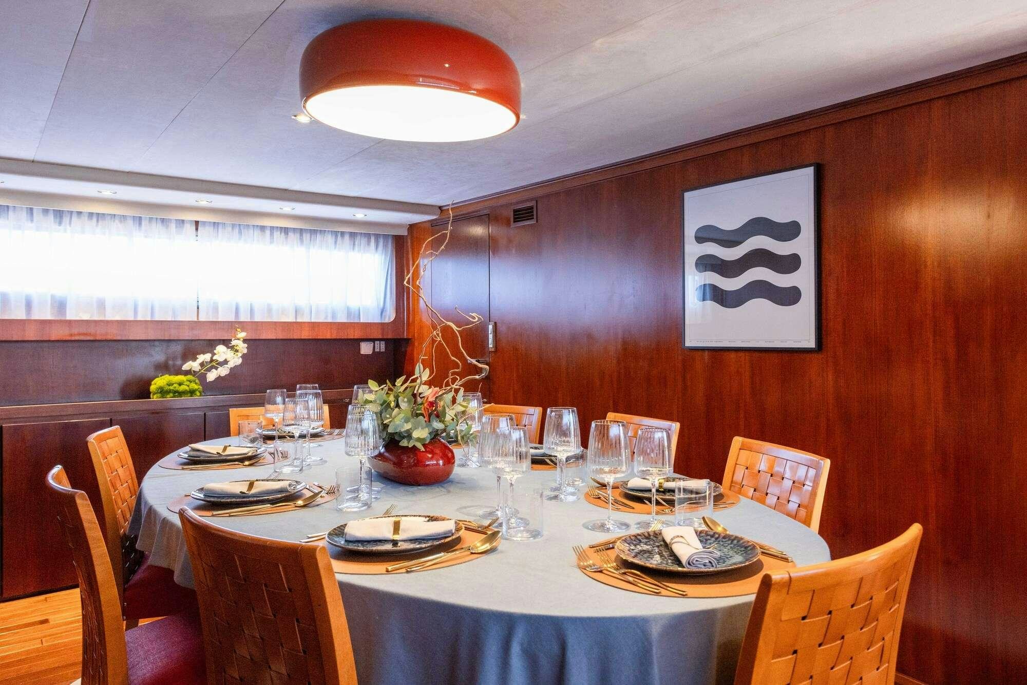 a dining room table set for a dinner party aboard OLGA Yacht for Charter