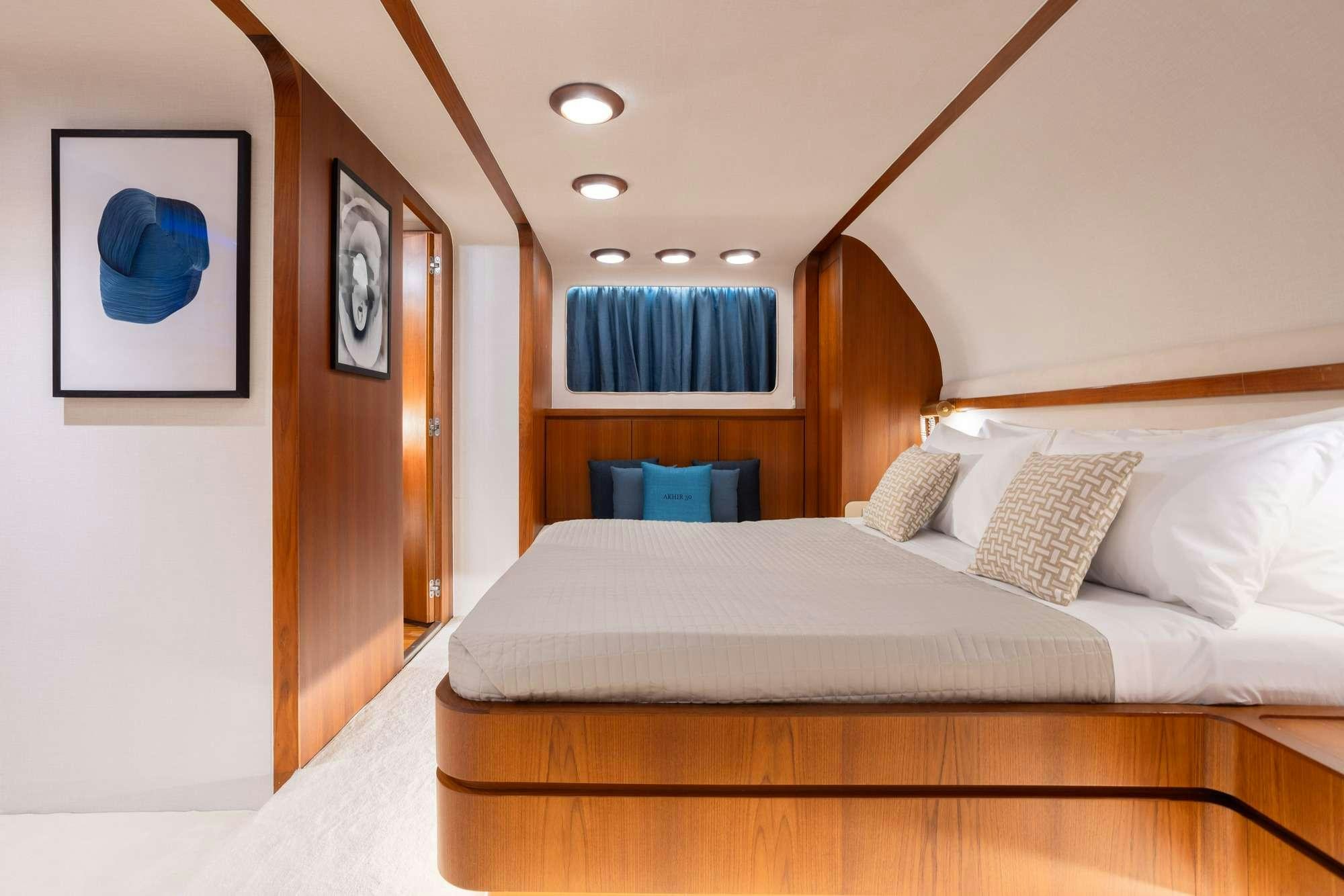 a bed with a white bed spread aboard OLGA Yacht for Charter