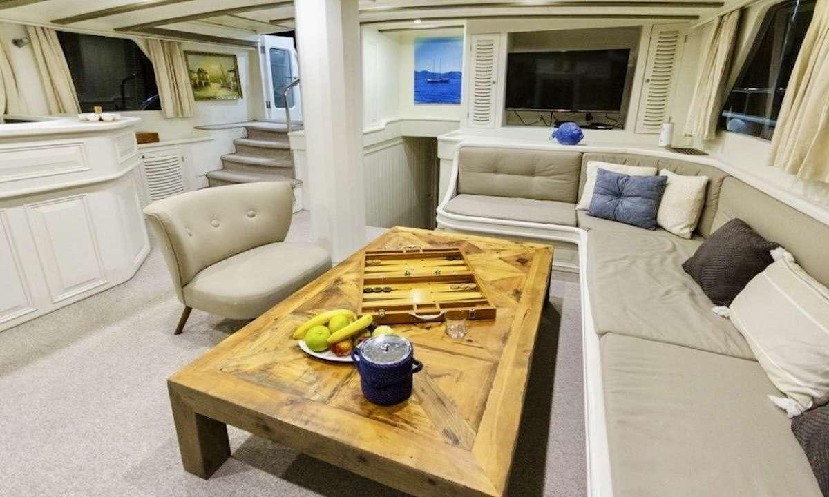a living room with a table and couches aboard THE BLUE SEA Yacht for Charter