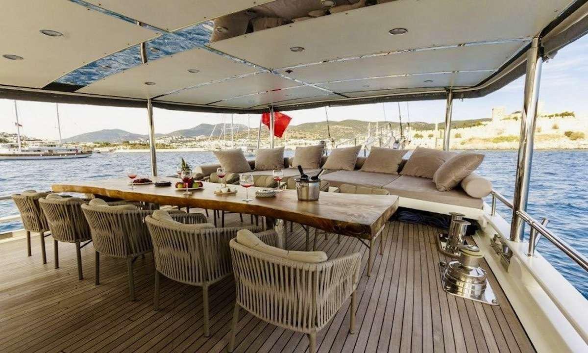 a deck with a table and chairs on it aboard THE BLUE SEA Yacht for Charter