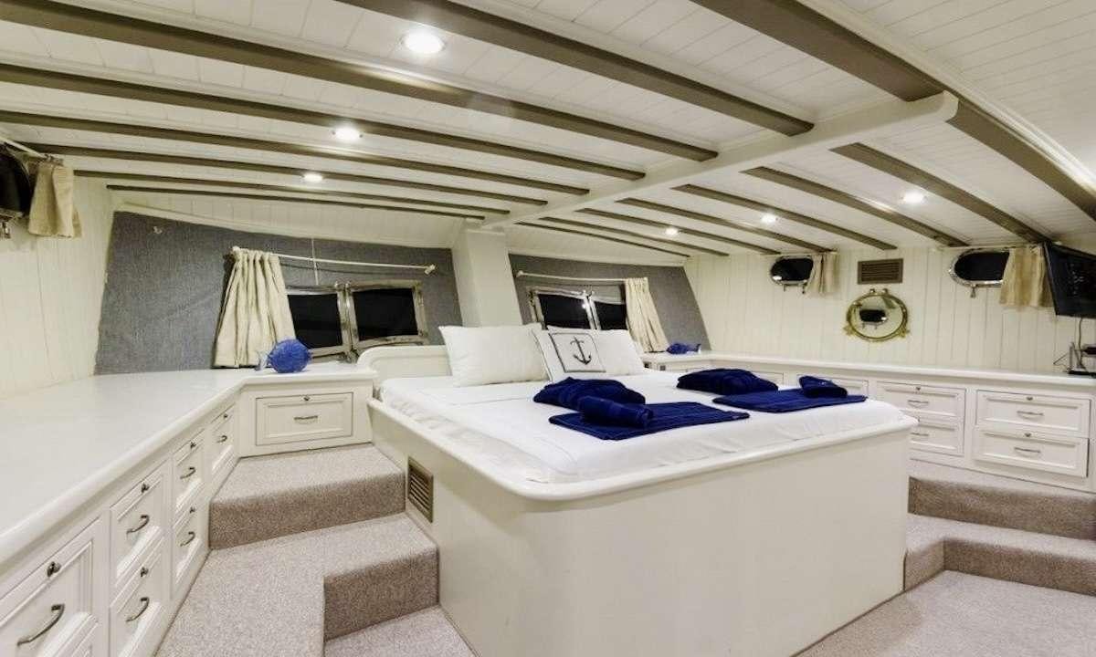 a room with a bed and a couch aboard THE BLUE SEA Yacht for Charter
