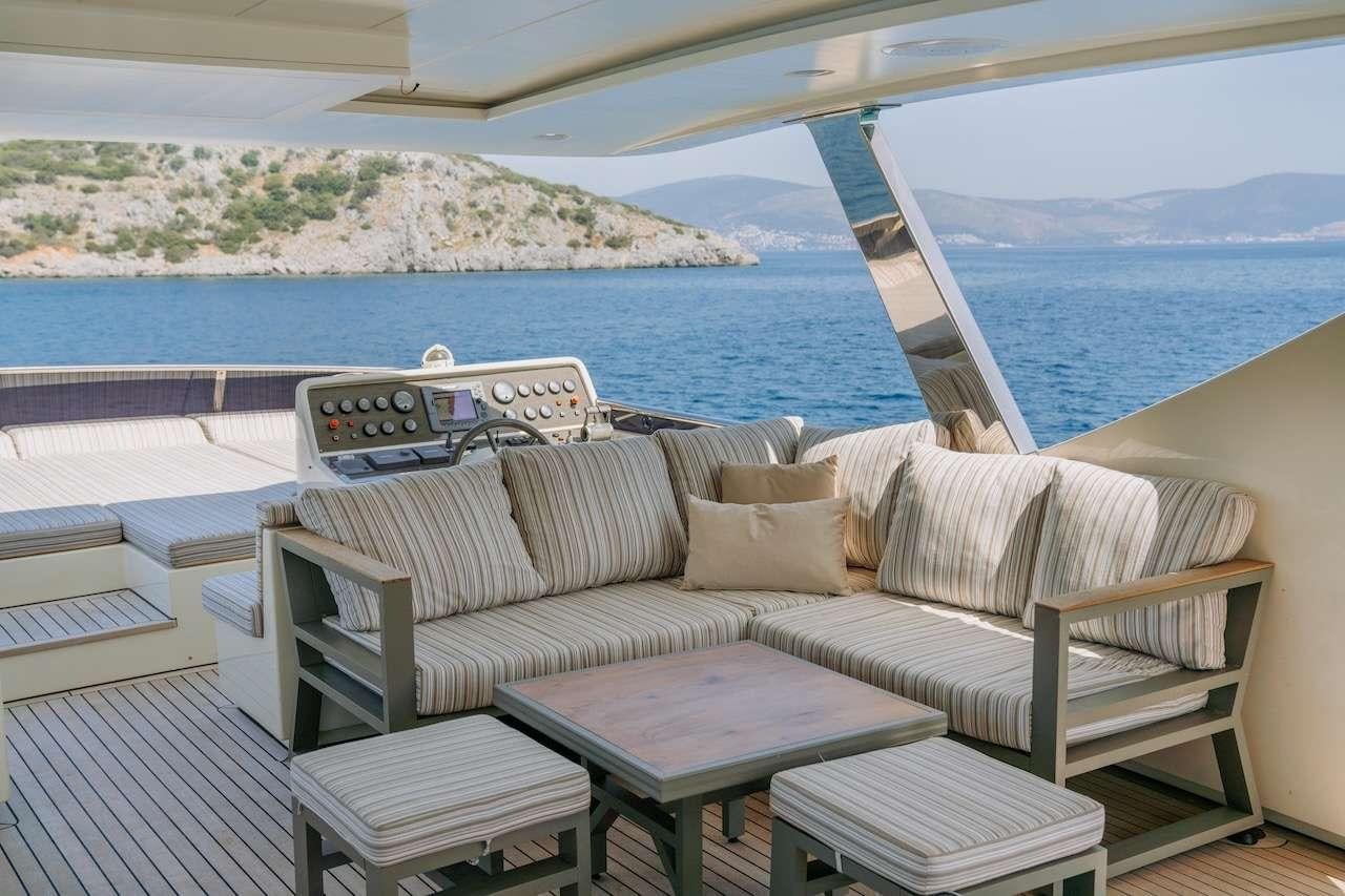 a couch on a porch overlooking a body of water aboard REIS Yacht for Charter