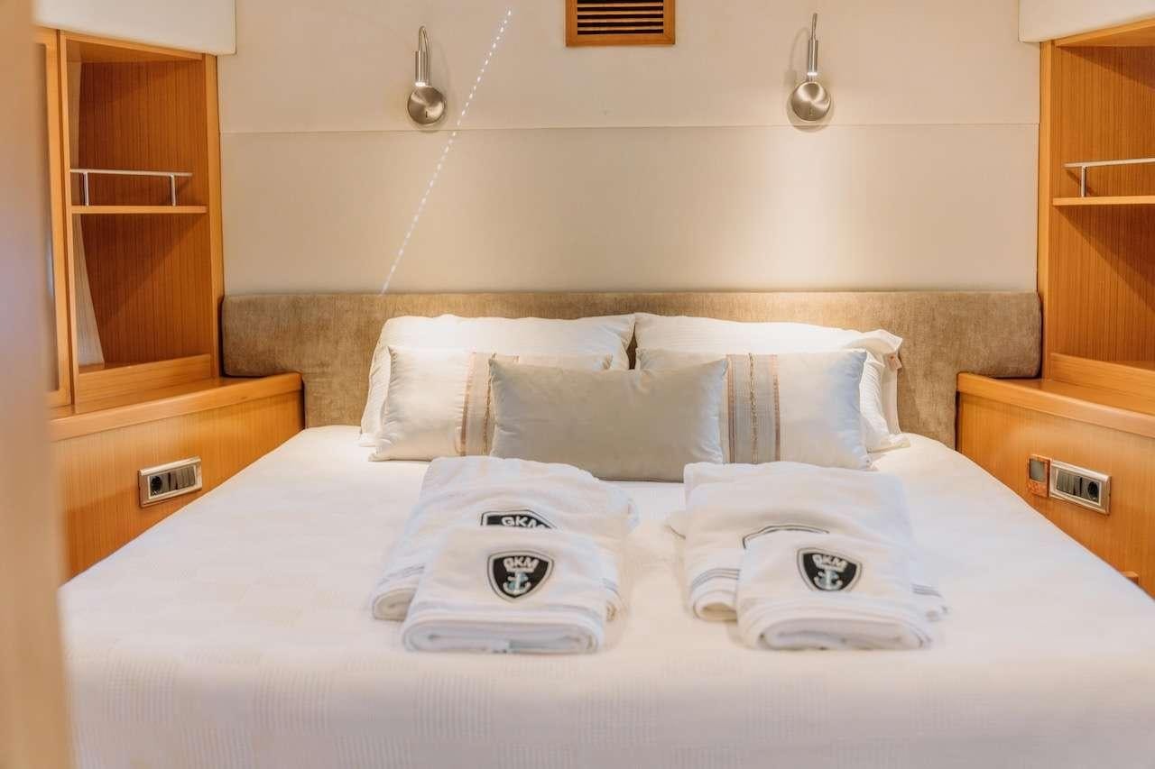 a bed with white pillows aboard REIS Yacht for Charter