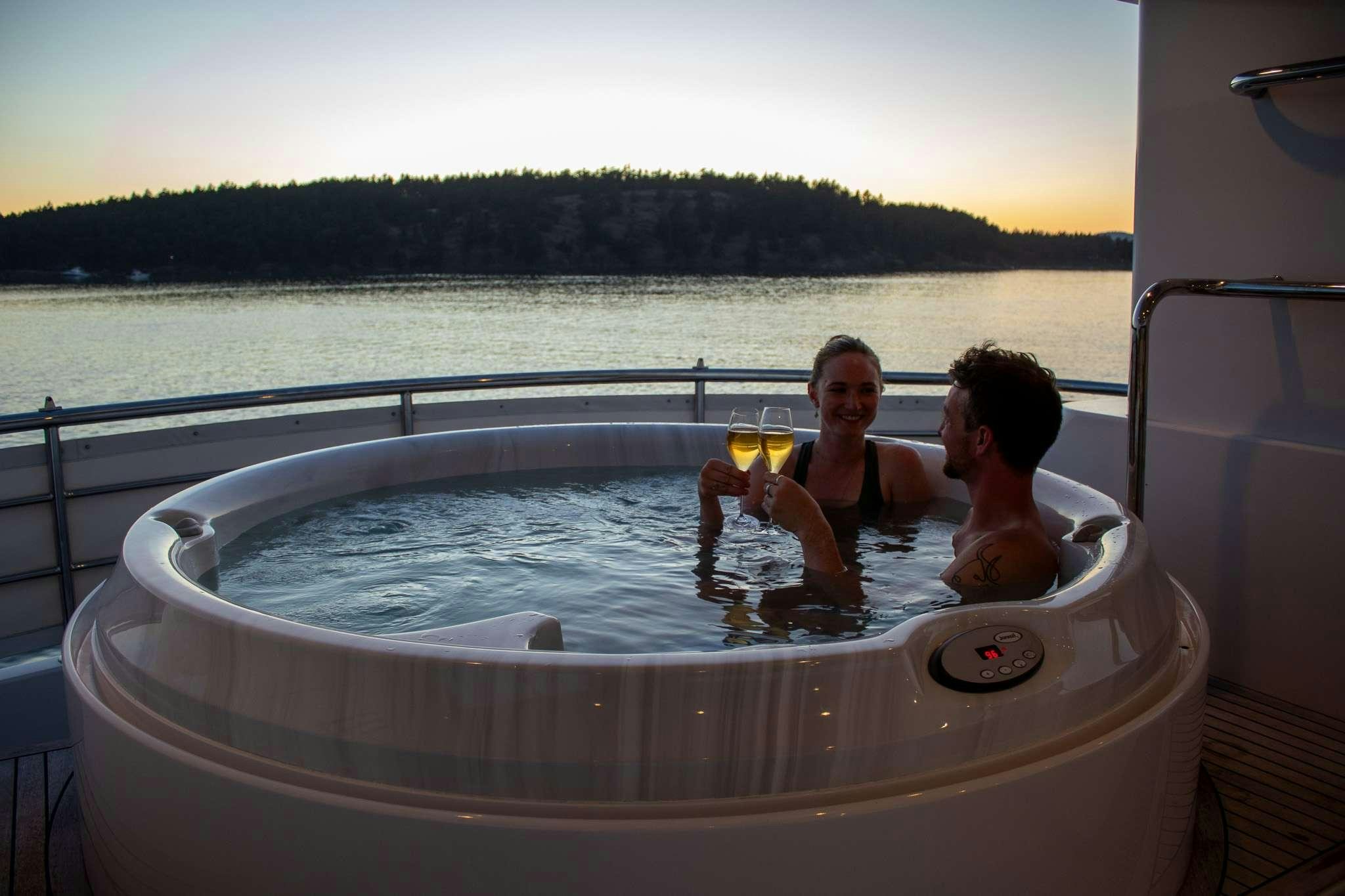 a couple of people in a hot tub with drinks aboard SERENDIPITY Yacht for Charter