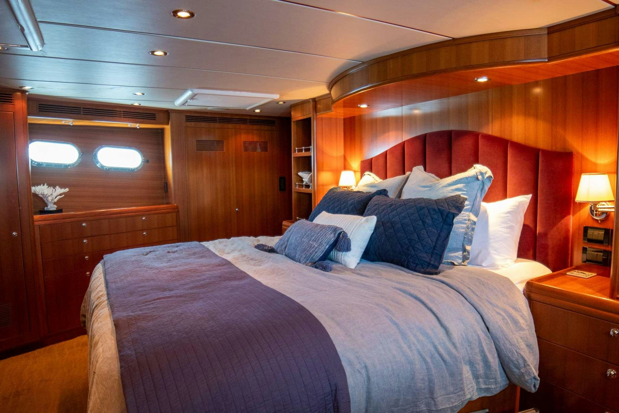 a bed with a blue comforter aboard SERENDIPITY Yacht for Charter
