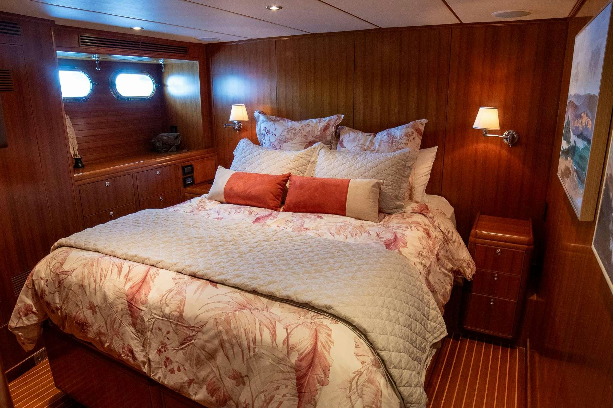 a bed with a brown comforter aboard SERENDIPITY Yacht for Charter