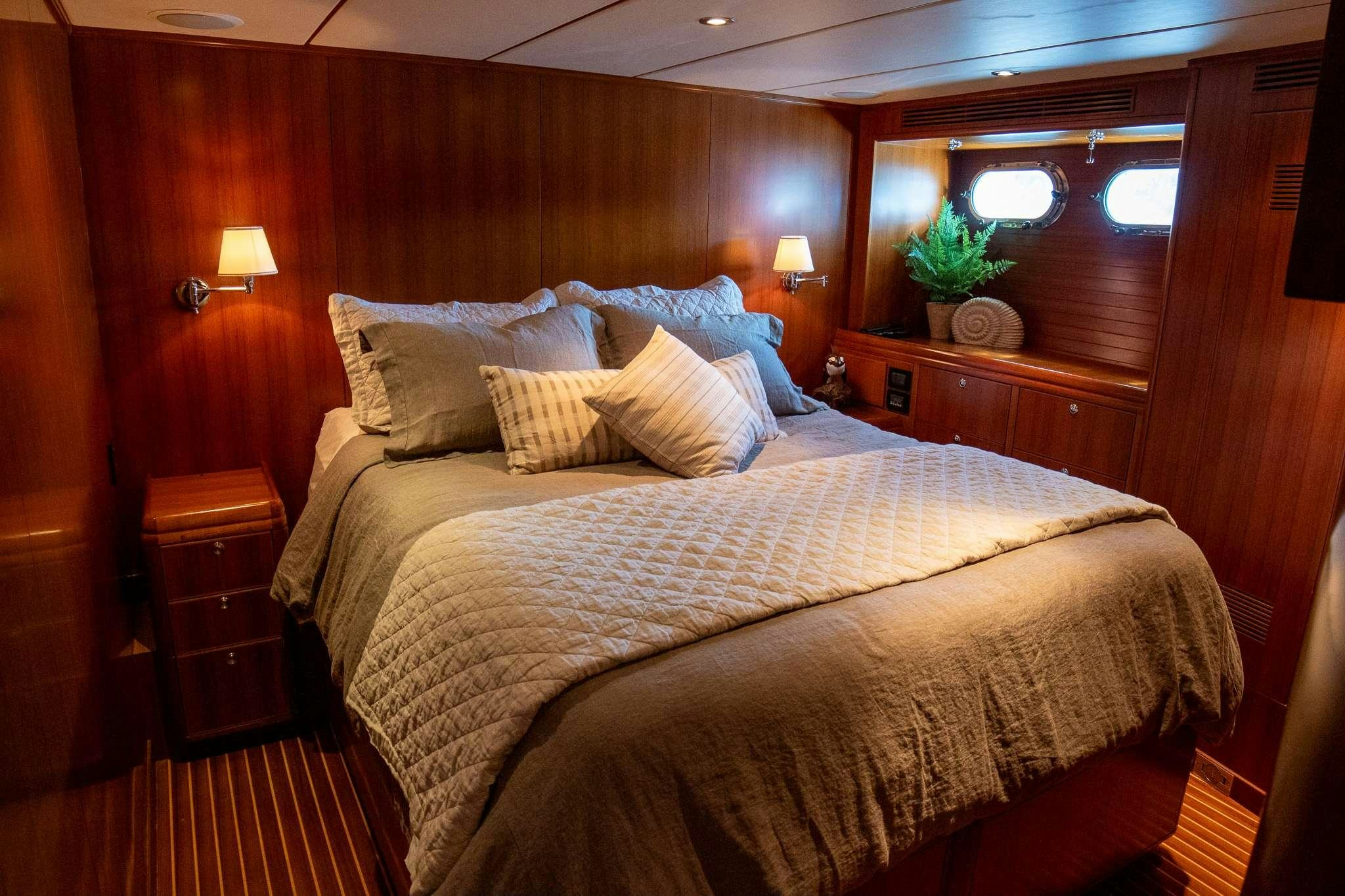 a bed with a large headboard aboard SERENDIPITY Yacht for Charter