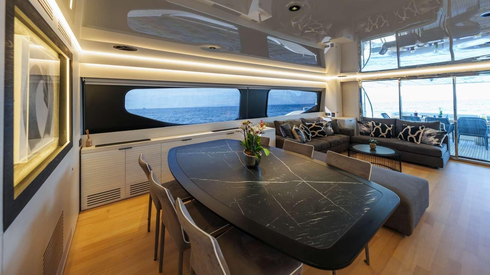 a living room with a large table and a large window aboard ALFA Yacht for Charter
