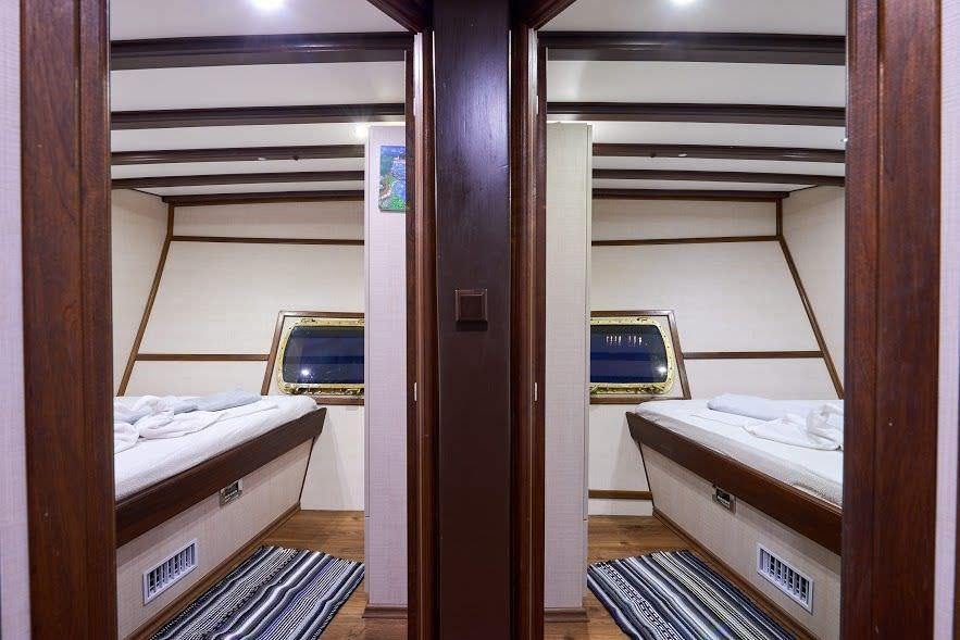 a room with a bed and a desk aboard NAUTILUS Yacht for Charter